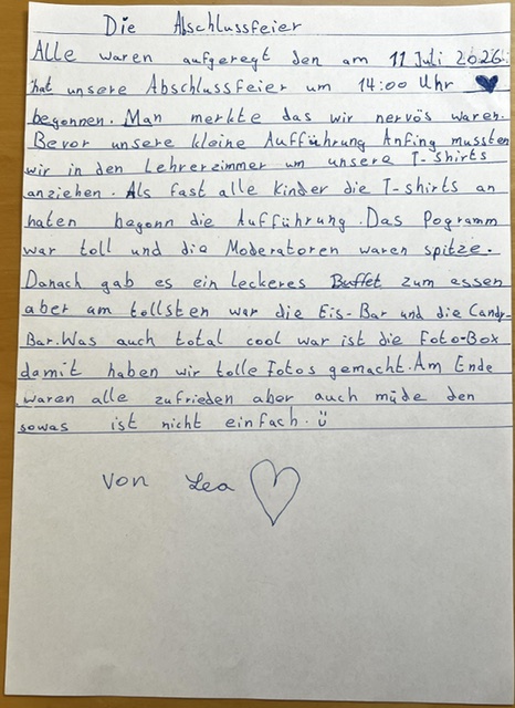Ein handgeschriebener deutscher Aufsatz mit dem Titel „Die Abschlussfeier“ auf liniertem Papier, in dem eine Schulabschlussfeier beschrieben wird; am Ende befindet sich eine Herzzeichnung.